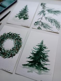 four watercolor paintings of evergreens and pine trees on white paper with marker pens