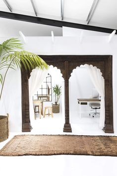 a living room with white walls and an arch in the center, covered by curtains