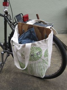 a bicycle parked next to a building with a bag on it's handlebars