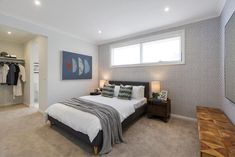 a bedroom with a bed, dresser and clothes on hangers in the closet area