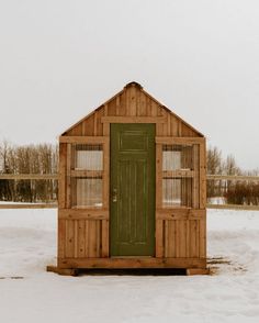 a small wooden outhouse sitting in the snow