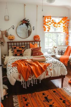 a bedroom decorated for halloween with orange and white decorations on the walls, bedding, and rugs