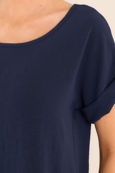 Elevate your wardrobe with our Elevated Classic Navy Short Sleeve Top. This versatile piece is perfect for any occasion. With its elevated and unique design, you'll stand out from the crowd while feeling comfortable and confident. Grab yours today and experience the perfect blend of style and comfort. This top features a crew neckline, a folded cuff sleeve, and an intentional back seam detail. 100% Polyester Hand Wash Cold Unlined Imported Model is wearing a size small Casual Navy Summer Shirt, Casual Navy Summer T-shirt, Casual Cotton Tops With Curved Hem, Navy Summer T-shirt, Navy Casual Shirt With Relaxed Fit, Casual Solid Color Tops With Rolled Sleeves, Casual Tops With Rolled Sleeves, Navy Relaxed Fit T-shirt For Summer, Casual Short Sleeve Top With Rolled Sleeves