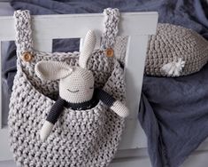 a crocheted bag with a stuffed animal hanging from it's front pocket