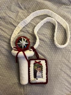 a crocheted white bag with a red and white star hanging from it's side