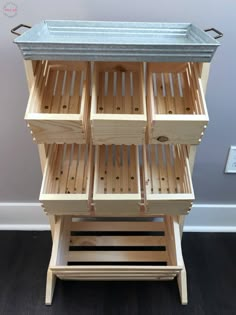 a wooden cabinet with drawers and metal trays on the top, in front of a wall