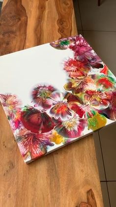 the table is made out of wood and has flowers painted on it with acrylic paint