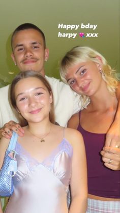 two women and a man standing next to each other in front of a birthday card