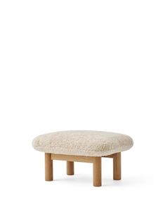 a small stool made out of wood and sheepskin on the top, with a white background