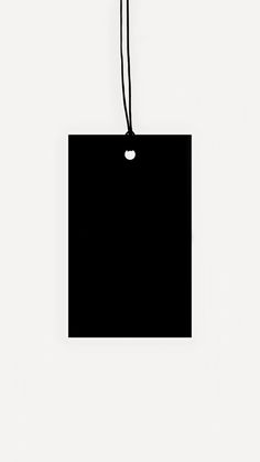 a black tag hanging on a white wall