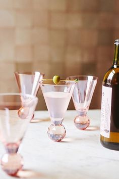 several wine glasses and a bottle on a table