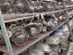 many metal pots and pans are stacked on shelves