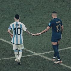 two soccer players are shaking hands on the field