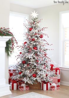 a white christmas tree with red and silver ornaments