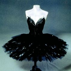 a mannequin wearing a black dress on display