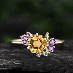 a yellow and purple ring sitting on top of a piece of wood