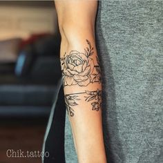 a woman's arm with a rose tattoo on the left side of her arm