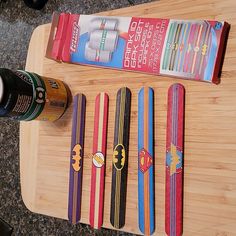 a wooden cutting board topped with different colored skis next to a bottle of beer