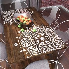 a wooden table with chairs around it and a bowl of fruit on top of it