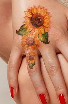 a woman's hand with a sunflower tattoo on it