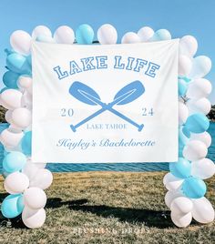 the lake life sign is surrounded by blue and white balloons