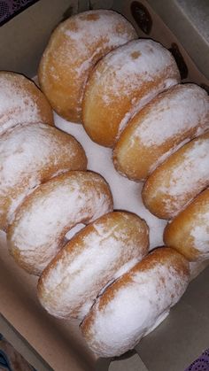 a box filled with donuts covered in powdered sugar