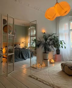 a living room filled with lots of furniture and plants on top of a wooden floor