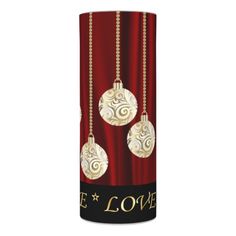 two christmas ornaments are hanging from a red can with the words be loved on it