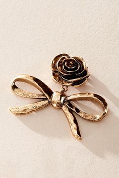 Add a classic touch to every style with this subtle yet special brooch featured in a femme design with hammered metal bow and rose-inspired detail at top for a super femme finish. | Rosie Brooch by Free People in Gold Shawl With Broach, Gold Brooch Jewelry, Jewelry Gold Necklaces, Gold Jewelry Collection, Metal Bow, Hammered Metal, Brooch Jewelry, Gold Brooches, Gold Necklaces