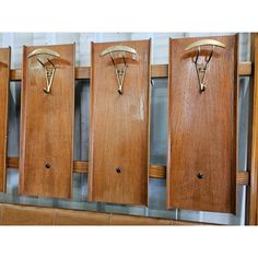 four wooden coat racks with hooks on them