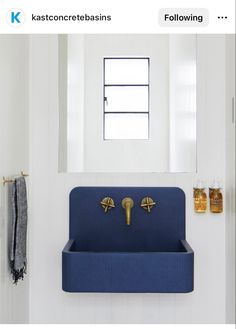 a blue sink sitting under a window in a bathroom