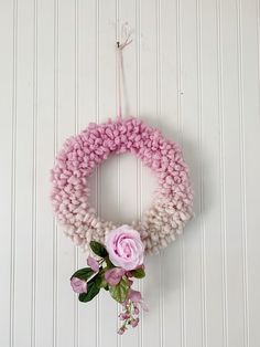 a pink wreath hanging on the wall