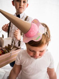 two young children wearing ice cream cones on their heads