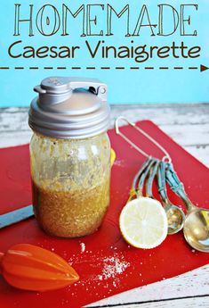 homemade caesar vinaigrete recipe in a mason jar with spoons and lemon