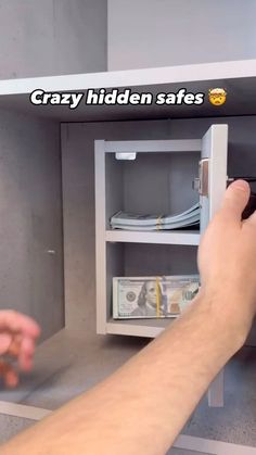 a man is opening a safe with money in the other hand and text that reads crazy hidden safes