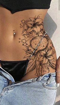 a woman's stomach with tattoos on it and flowers in the middle of her stomach