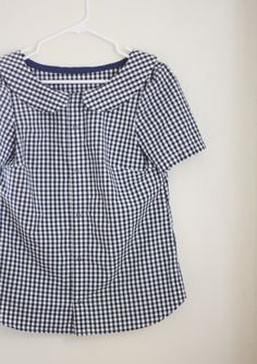 a blue and white checkered shirt hanging on a wall