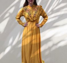 Gorgeous 70s style maxi dress in pumpkin yellow color . Features ruffled neckline with buttons, covered in the same fabric , flowers embroidery , long sleeves and elasticated hight waist . Doesn't have a zipper , it is pull on dress. This item is in style of the 70s but it is 00s item . Material tag is missing , but it is viscose - very soft . Labeled as size S / M would fit both sizes . Length - approx 158 cm , chest - 94 cm , width waist - 60 cm to 88 cm maximum . Vey good vintage condition Yellow Long Sleeve Maxi Dress With Ruffles, Yellow Ruffled Long Sleeve Maxi Dress, Yellow Long Sleeve Ruffled Maxi Dress, Yellow Maxi Dress For Fall, Yellow Bohemian Maxi Dress With Floral Embroidery, Bohemian Orange Maxi Dress With Ruffles, Yellow Bohemian Maxi Dress For Fall, Mustard Bohemian Maxi Dress, Spring Embroidered Yellow Maxi Dress