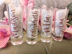 three glasses with the word dream written on them are sitting next to pink flowers and petals