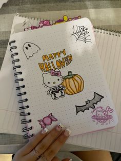 a person holding a notebook with halloween stickers on it and the words happy halloween