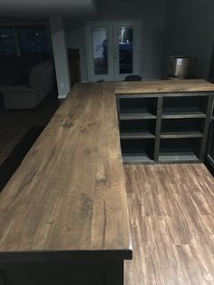 an empty kitchen with wood flooring and cabinets