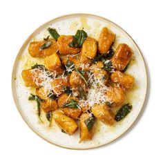 a white plate topped with chicken and spinach covered in parmesan cheese