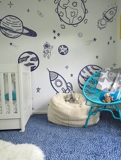 a child's room with space themed wallpaper and blue rugs on the floor