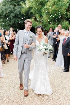 a bride and groom walk down the aisle as confetti flies in the air