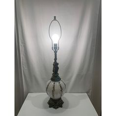 an antique lamp is on display against a white backdrop