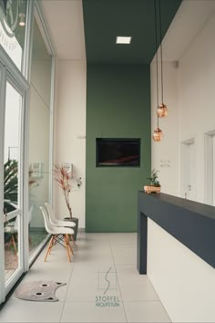 an empty room with green walls and white flooring