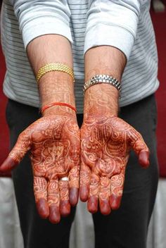 two hands that are covered in hendi and bracelets with designs on their palms