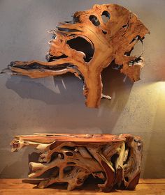 two pieces of driftwood are displayed on the wall next to a table and lamp