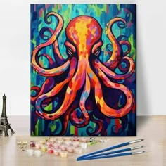 an octopus painting on a canvas next to some paintbrushes