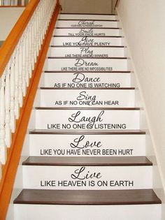 stairs with wall decals on the bottom and hand painted sayings above them in various languages